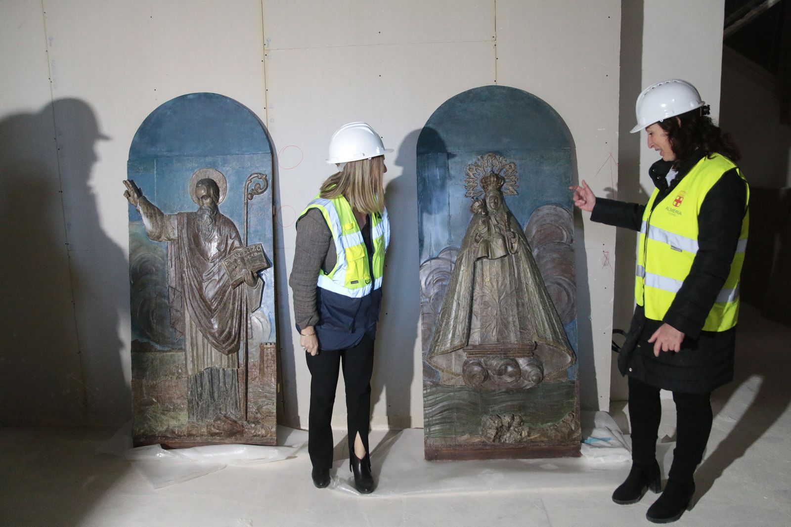 La consejera y la alcaldesa con los bajorrelieves de San Indalecio y la Virgen del Mar restaurados