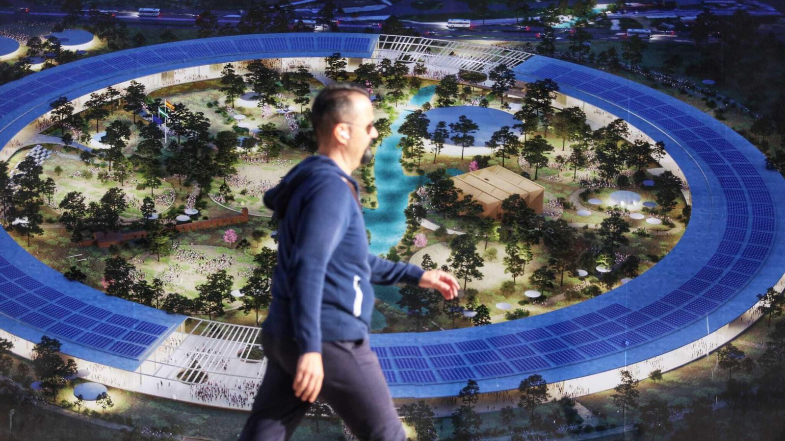 Un viandante pasa junto a un cartel con una infografía del futuro anillo de la Expo 27.