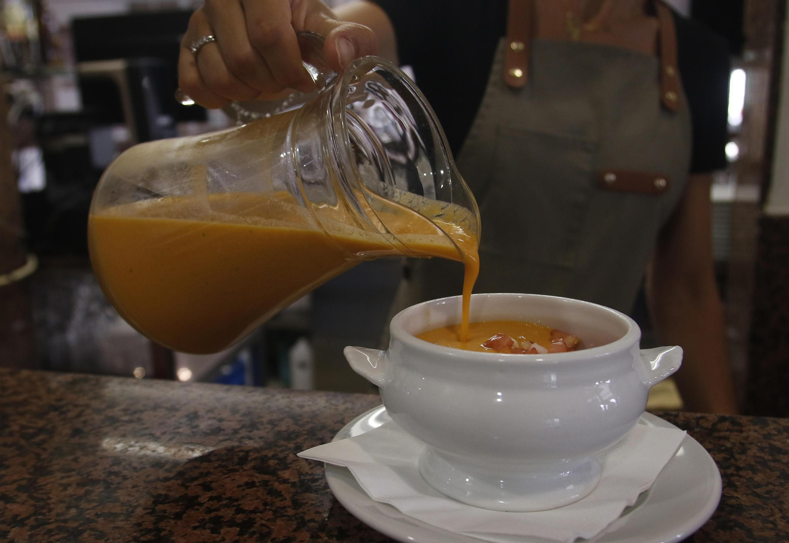 Una camarera sirviendo salmorejo Una camarera sirviendo salmorejo