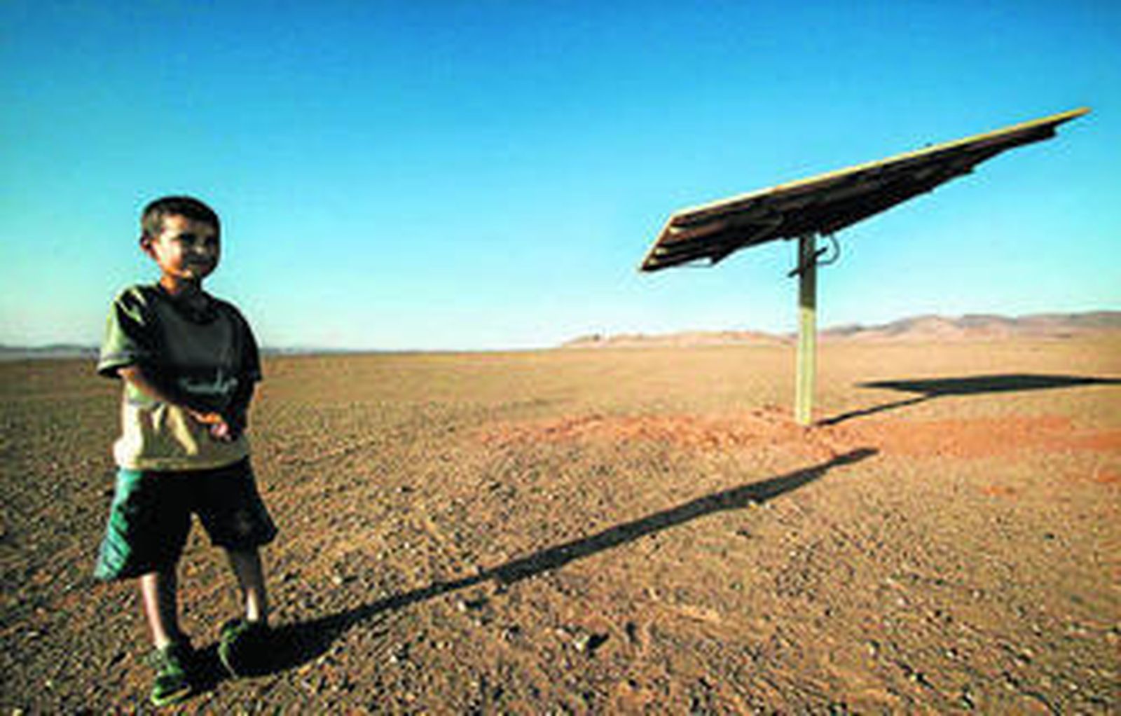 Un niño junto a un panel solar en un proyecto de electrificación rural de Isofotón en Marruecos.