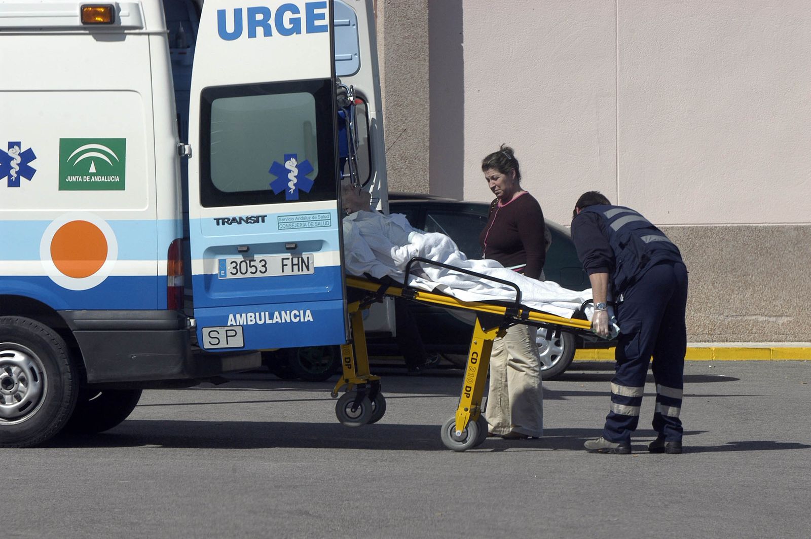 Un enfermo es trasladado en una camilla por los servicios de urgencias, a las puertas de un hospital.