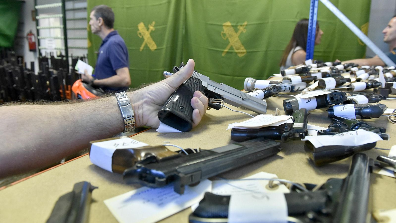 Un hombre muestra una pistola en la comandancia de la Guardia Civil.
