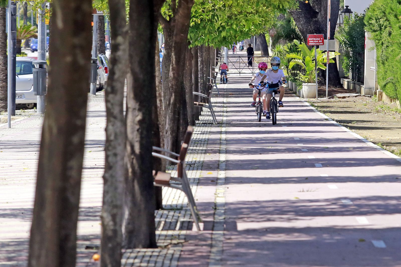 Dos niños montan en bici por una calle.