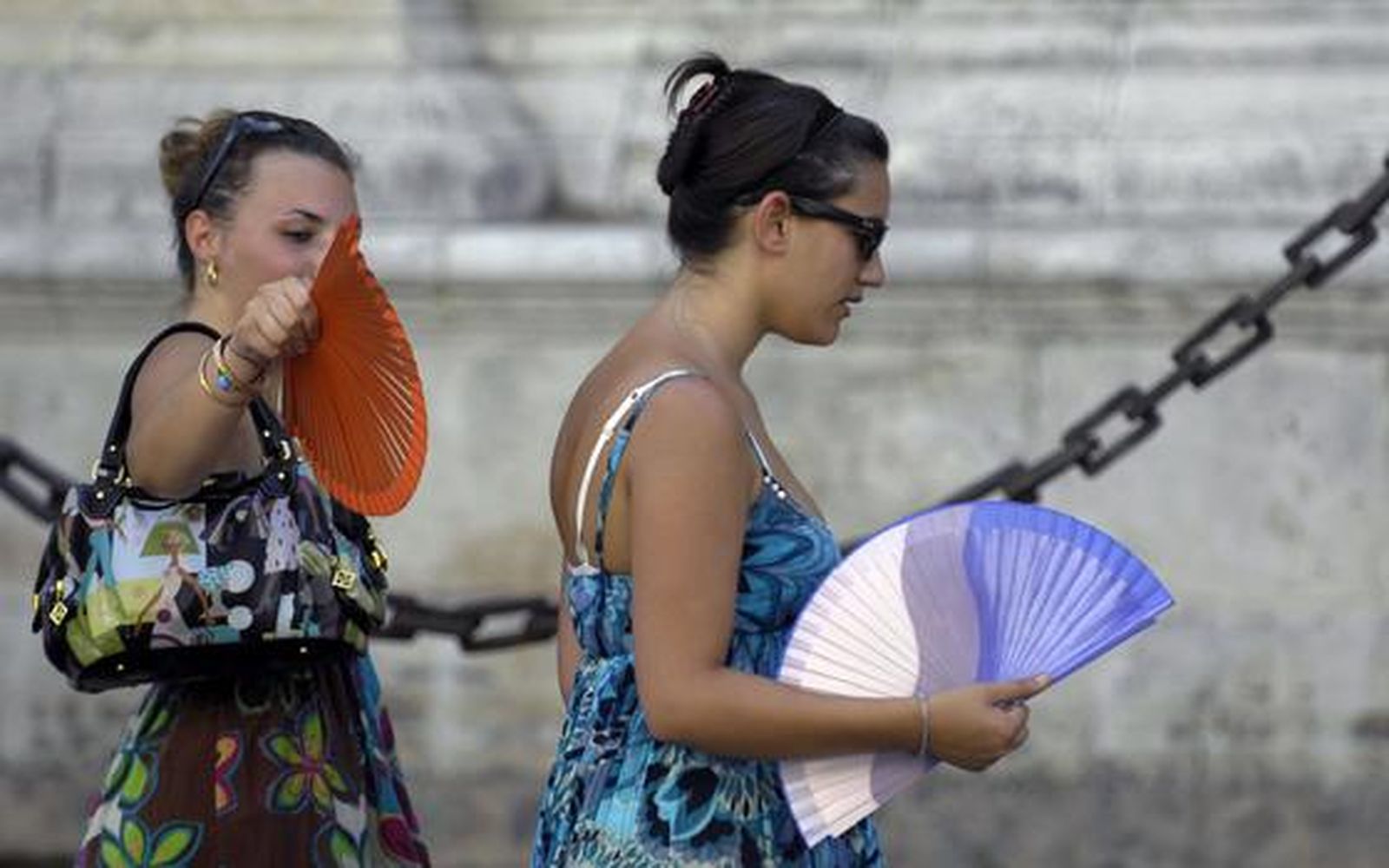 Dos chicas pasean abanicándose.   Foto: Manuel Gómez