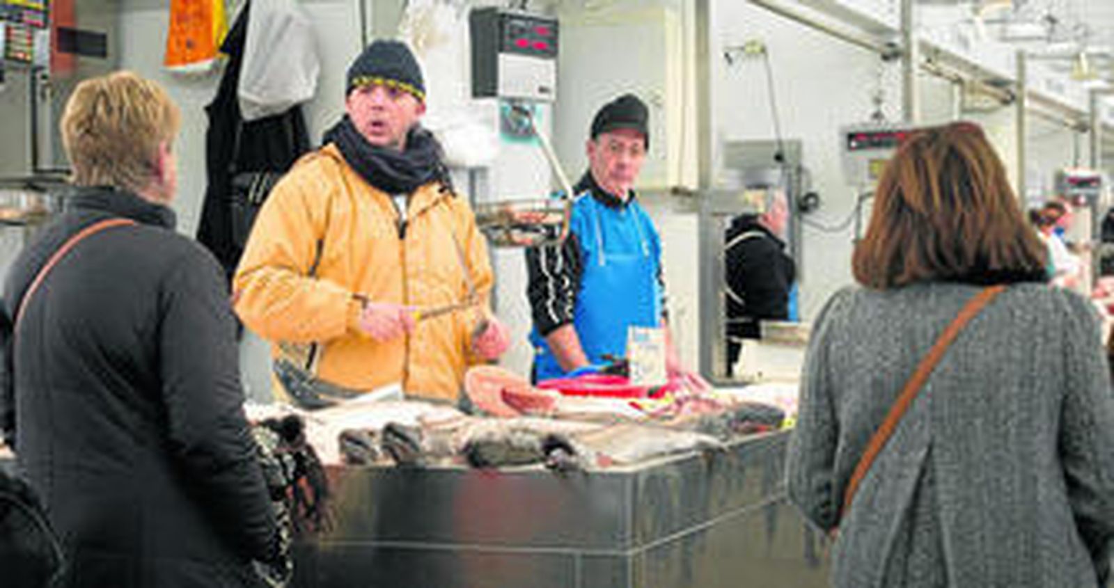 Personal de un puesto en el mercado de la capital gaditana, ayer, preparado para las bajas temperaturas que se avecinan.