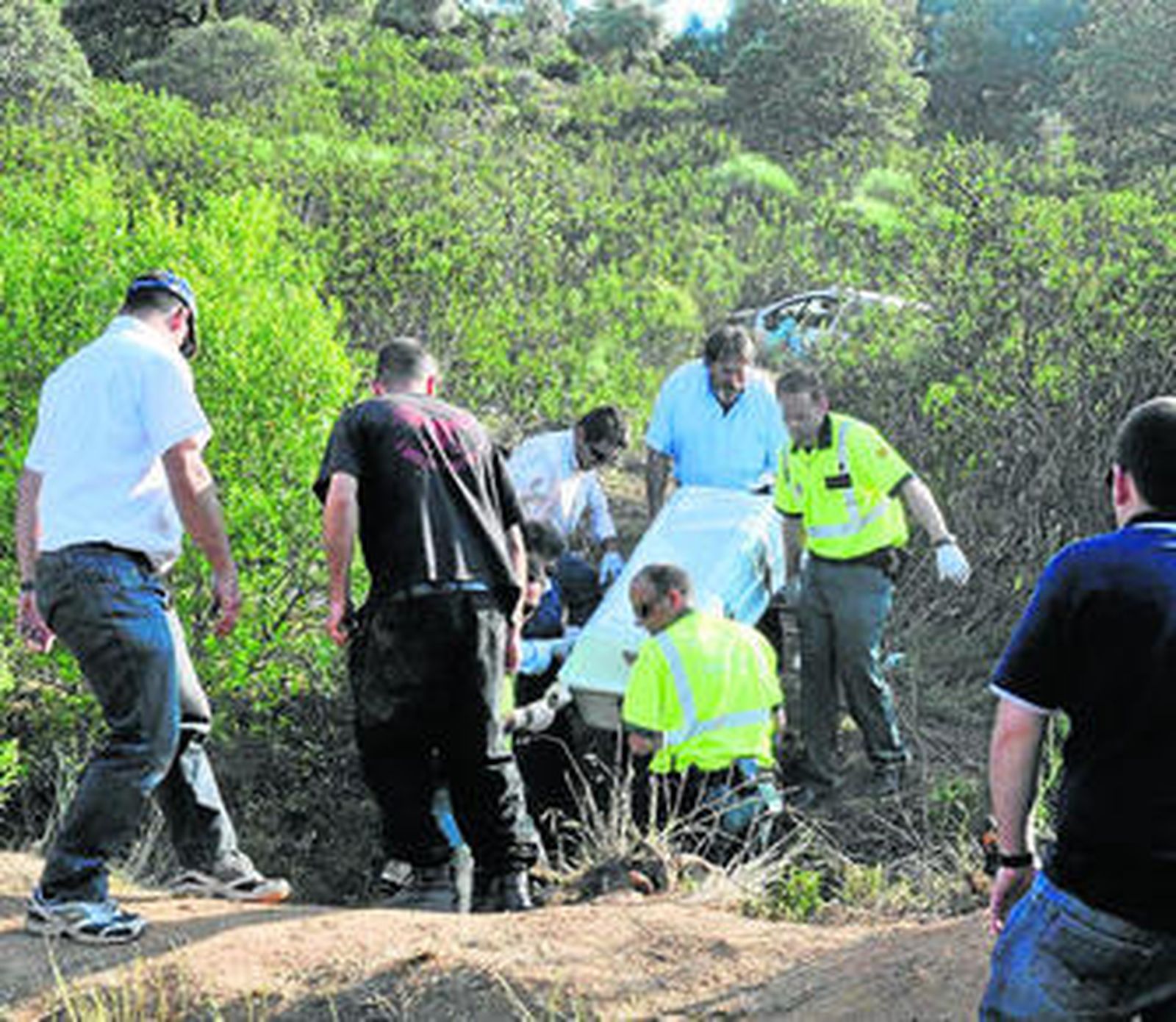 Las asistencias trasladan el féretro con el cuerpo de una de las víctimas del accidente.
