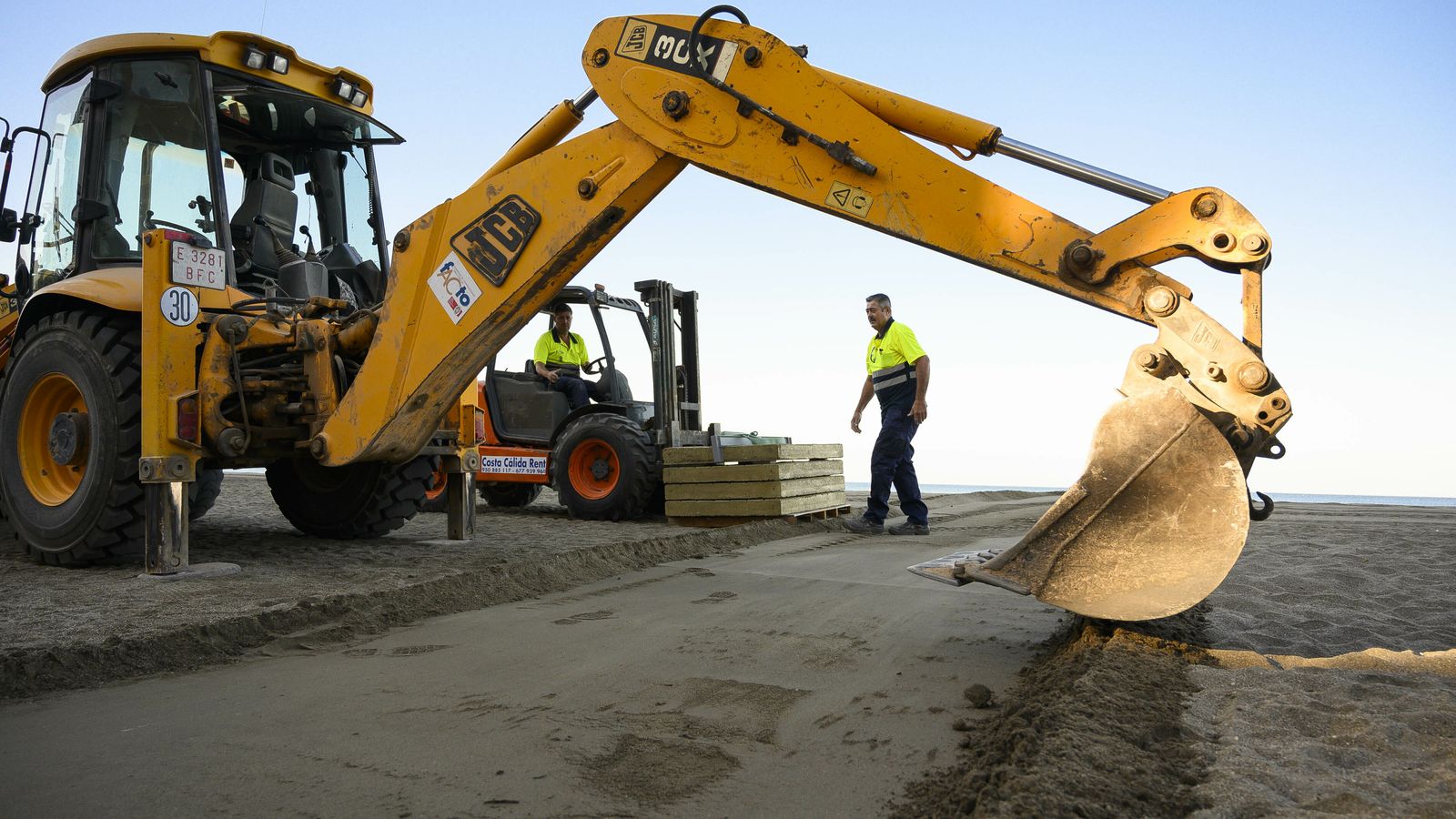 Preparando el pasillo antes de colocar sobre la arena las piezas de hormigón