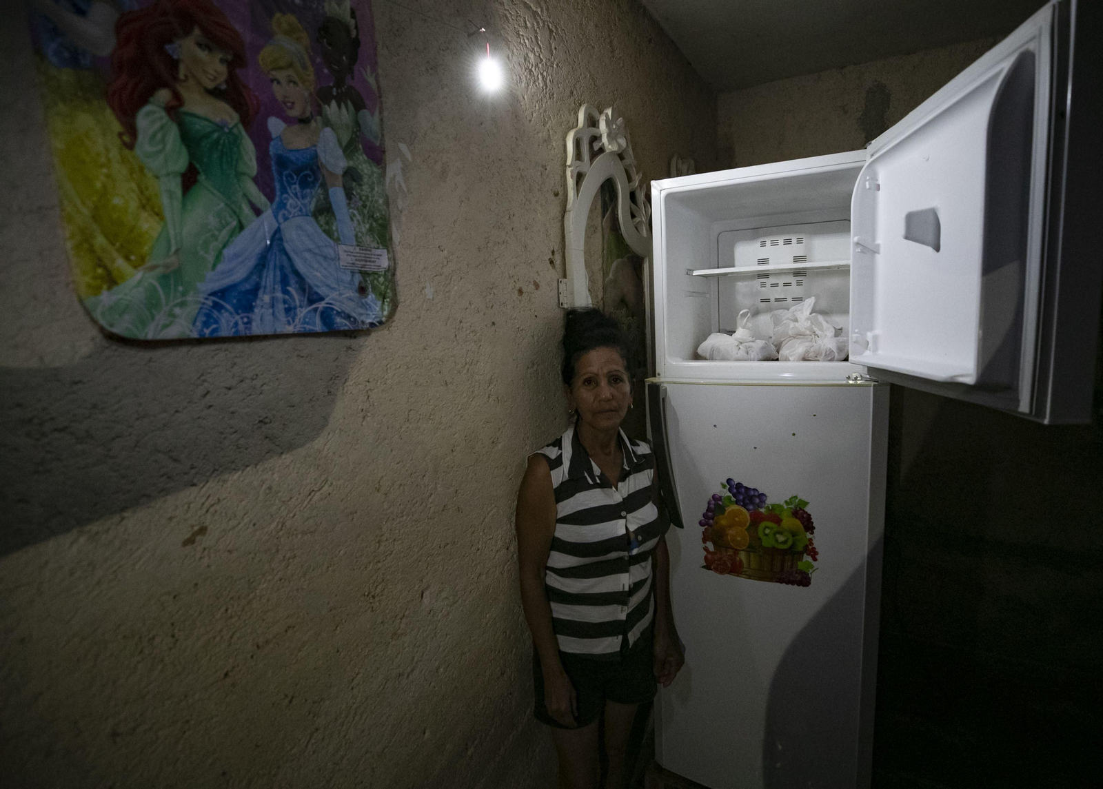 Una mujer muestra la nevera de su casa en Santa Ana, cerca de Varadero, en Cuba.