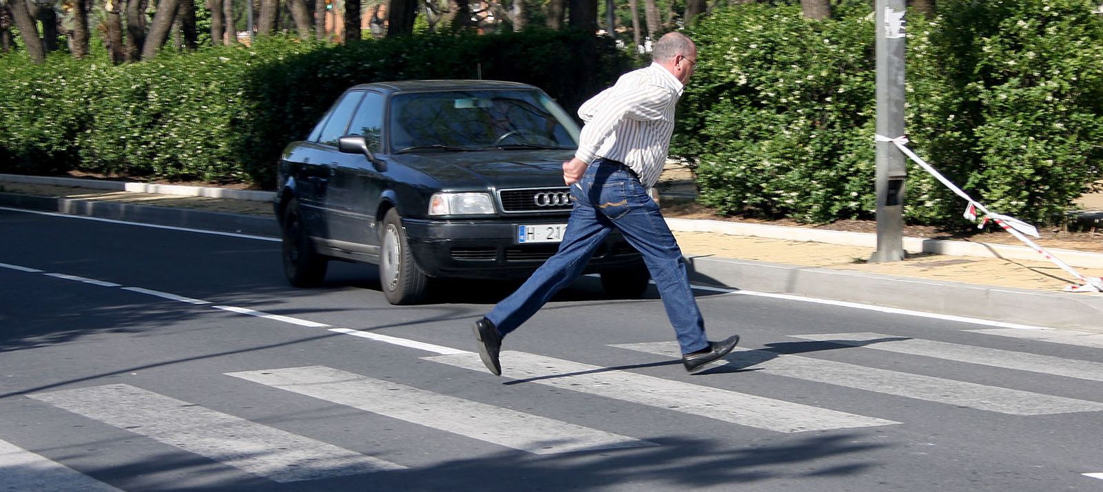 Un hombre cruza rápido por un paso de peatones