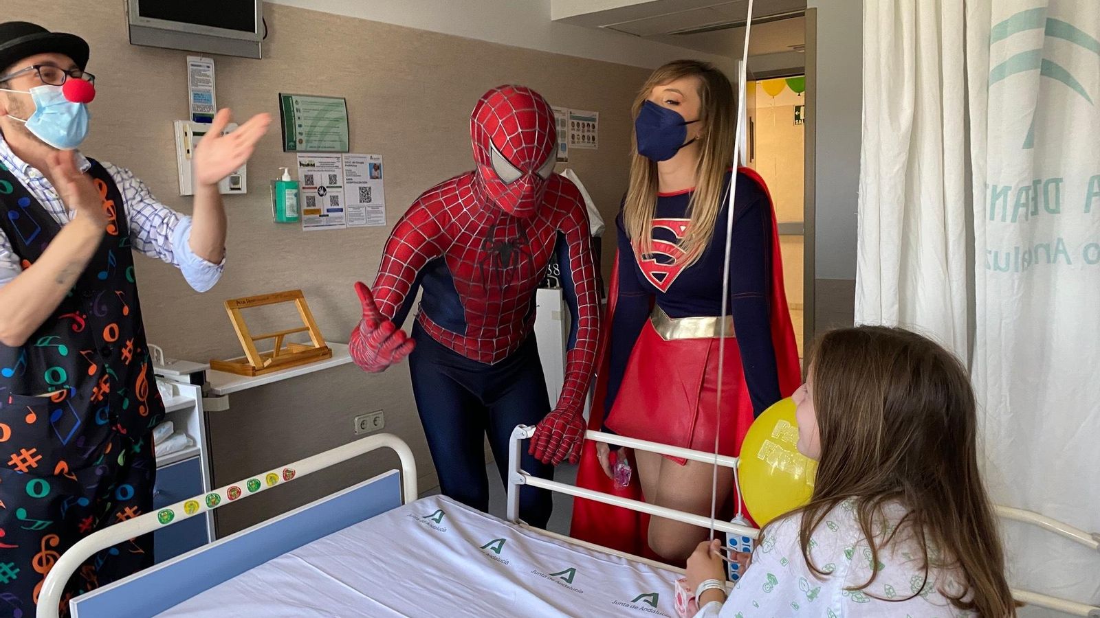 Payasos y superhéroes en la habitación de una niña ingresada.