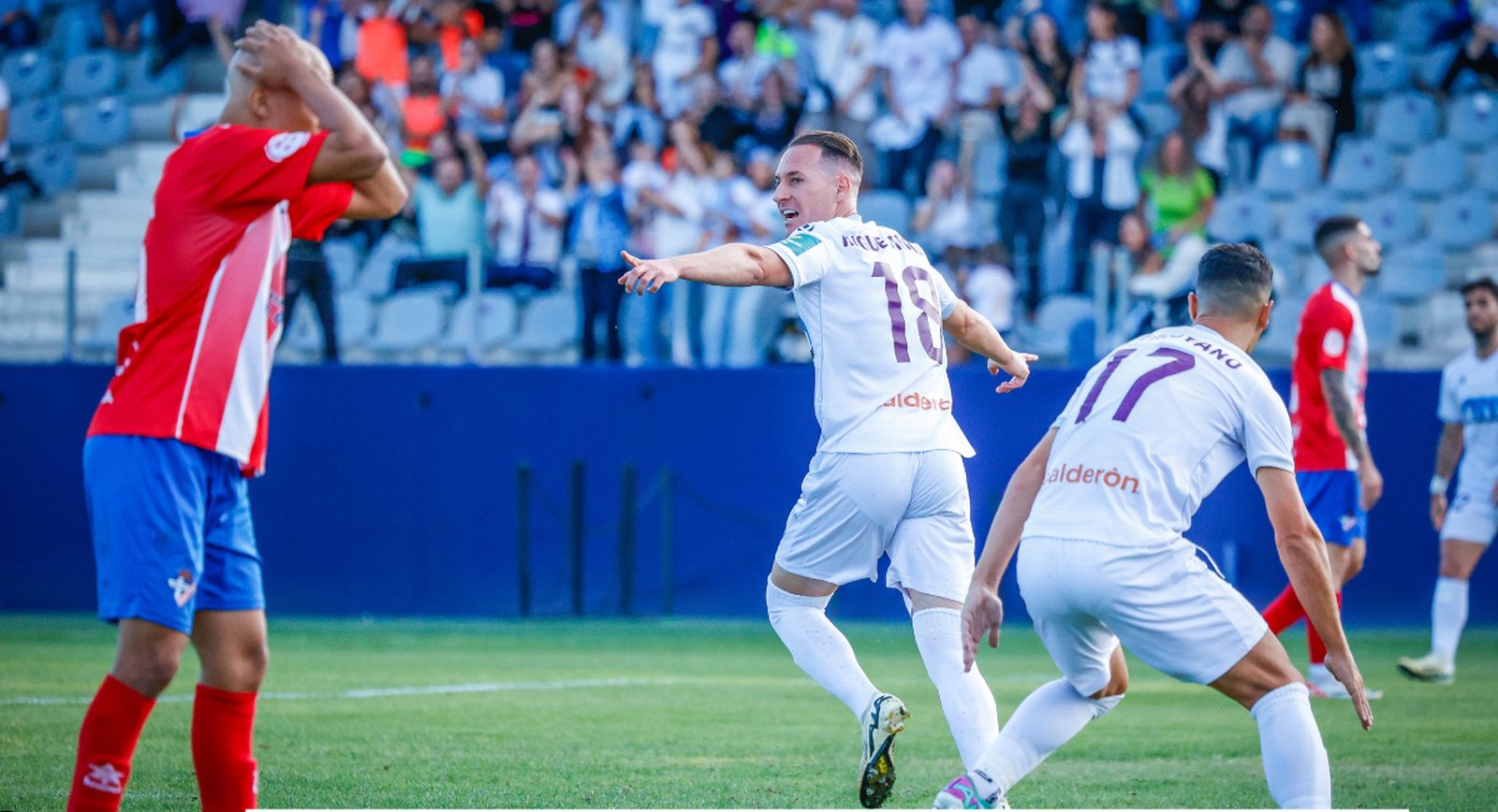 Los jienenses celebran uno de sus tantos frente a los almerienses ante la desesperación del rojiblanco Hamza.