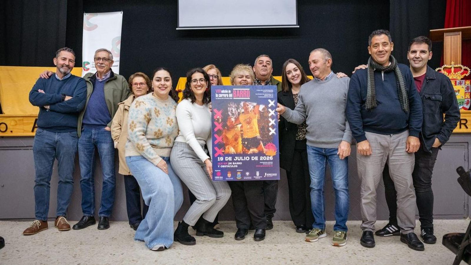 Miembros de la Asociación 1.000 km contra el Cáncer, con el cartel de la próxima edición de la Carrera del Barro de La Barca.
