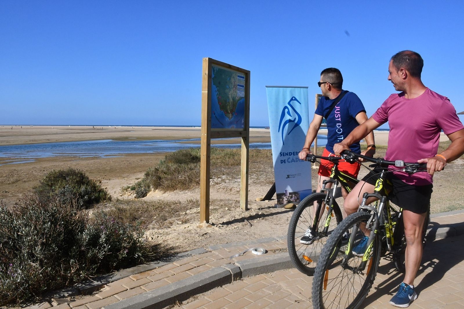 Ciclistas mirando el Mapa de Senderos de Cádiz.