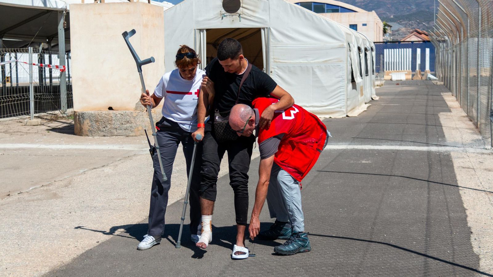 Imagen de archivo de dos voluntarios ayudando a una persona tras llegar al puerto de Motril