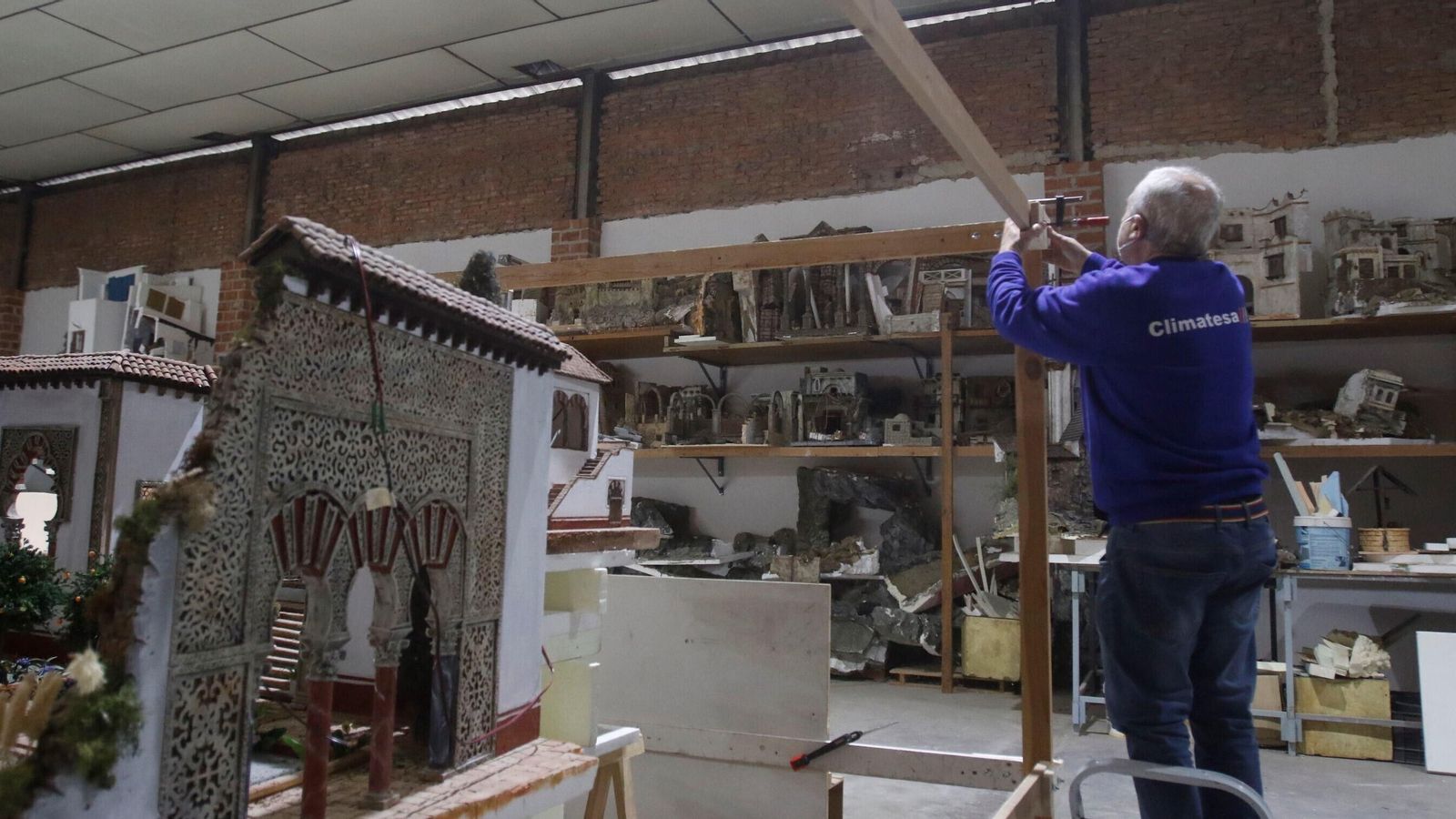 Un miembro de la asociación trabaja en un belén.