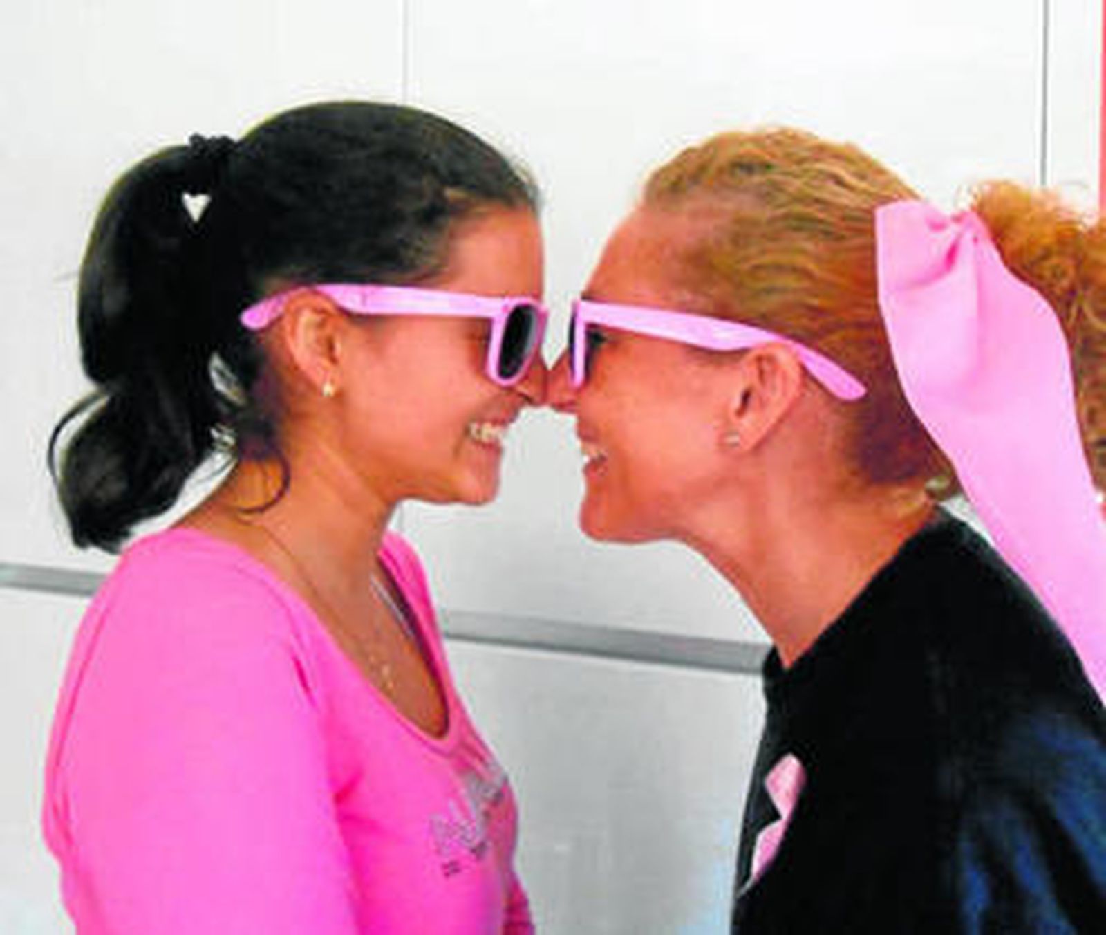 Dos mujeres con las gafas de pasta rosa que vende la AECC en Guadix.