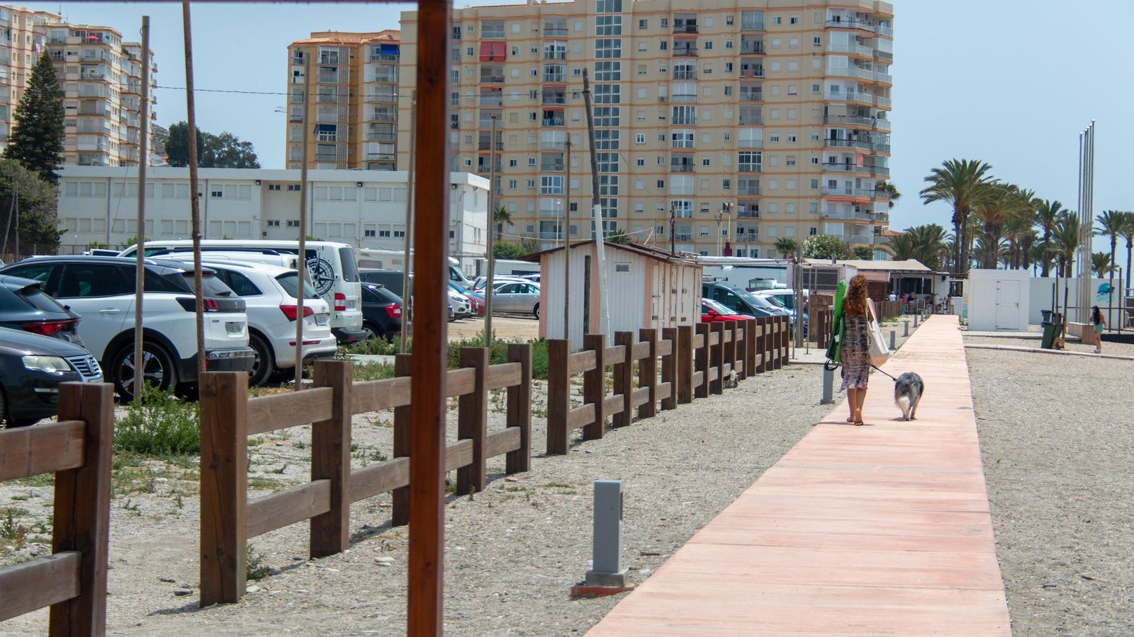 Una mujer camina junto al aparcamiento ubicado en la zona del ferial de Torrenueva Costa