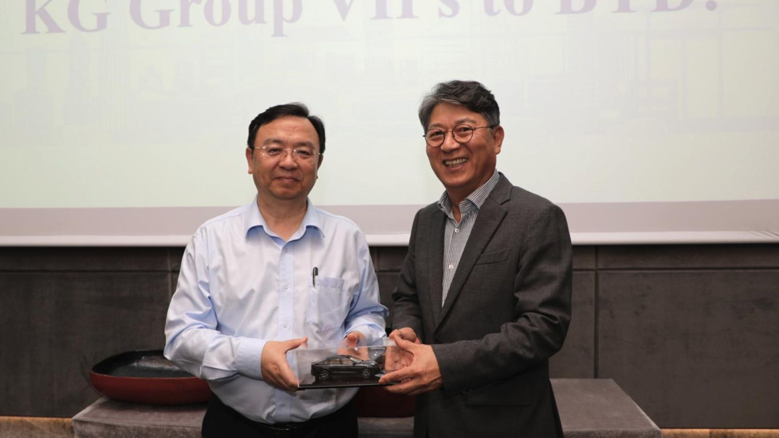 El presidente de BYD, Wang Chuanfu (izquierda), y el presidente de KG Mobility, Kwak Jae-sun, durante la ceremonia de firma de su nueva asociación en Shenzhen (China).