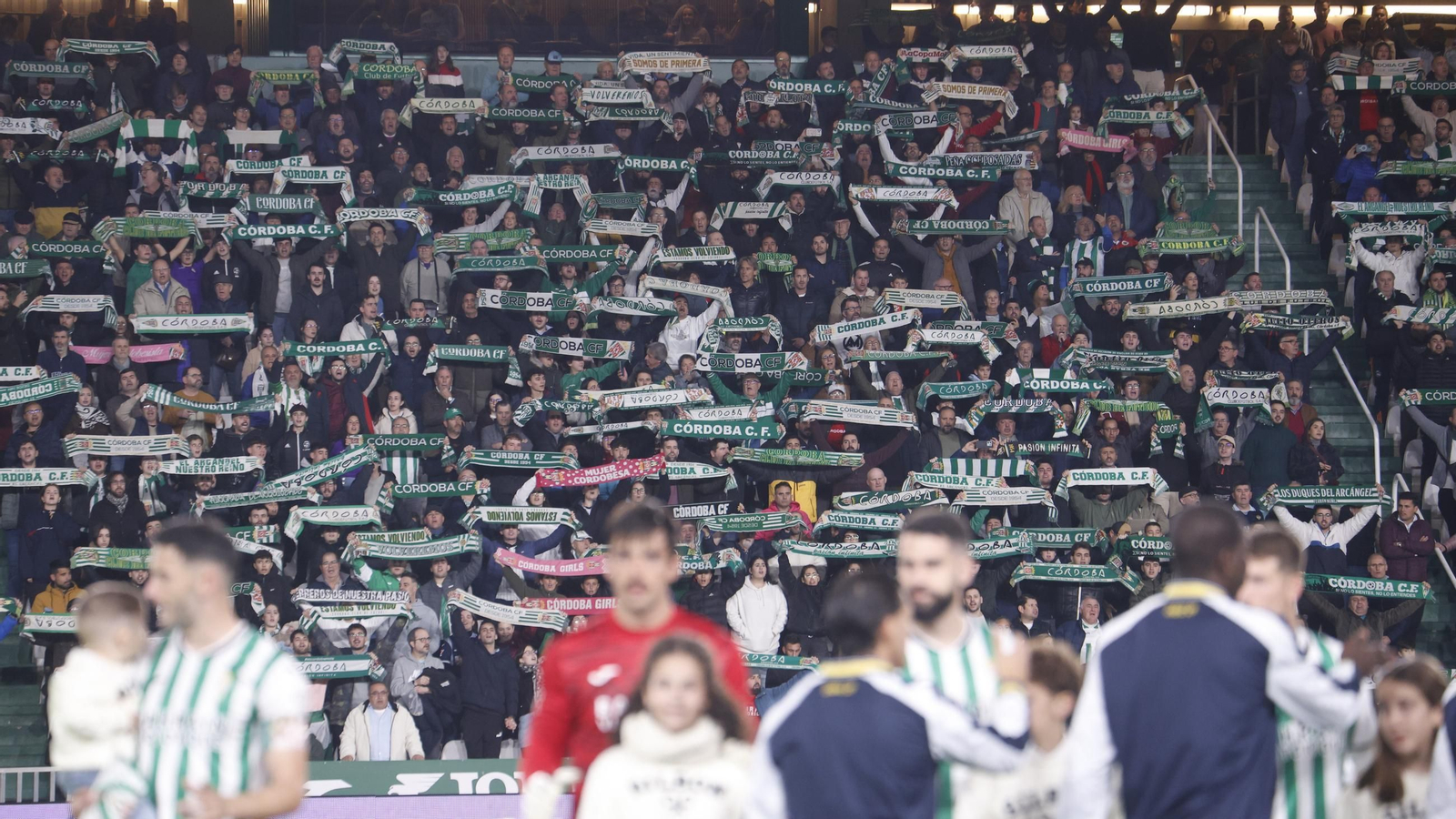 Los aficionados del Córdoba CF alzan las bufandas de su equipo antes del partido ante el Cádiz.