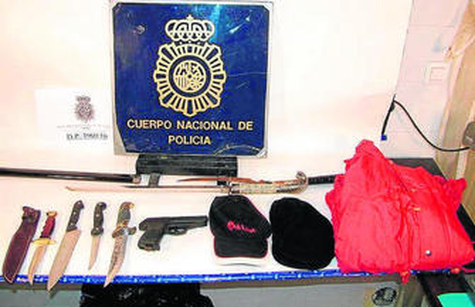 Pistola, cuchillos y catanas junto a las gorras intervenidas al atracador.