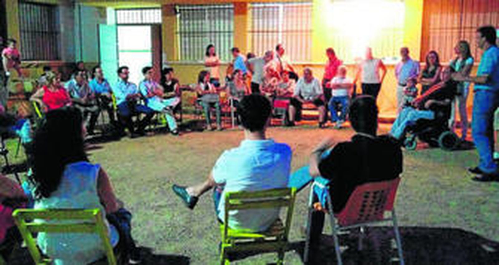 1. Reunión de presentación de 'El Alcor', a la que acudieron más de 50 personas. 2. Andy Jiménez, uno de los impulsores del proyecto, entrega la cartilla de dinero social a una de las asistentes. A su lado, unos artículos de hojas de palma seca, que pueden adquirirse en el mercadillo con esta nueva forma de pago.