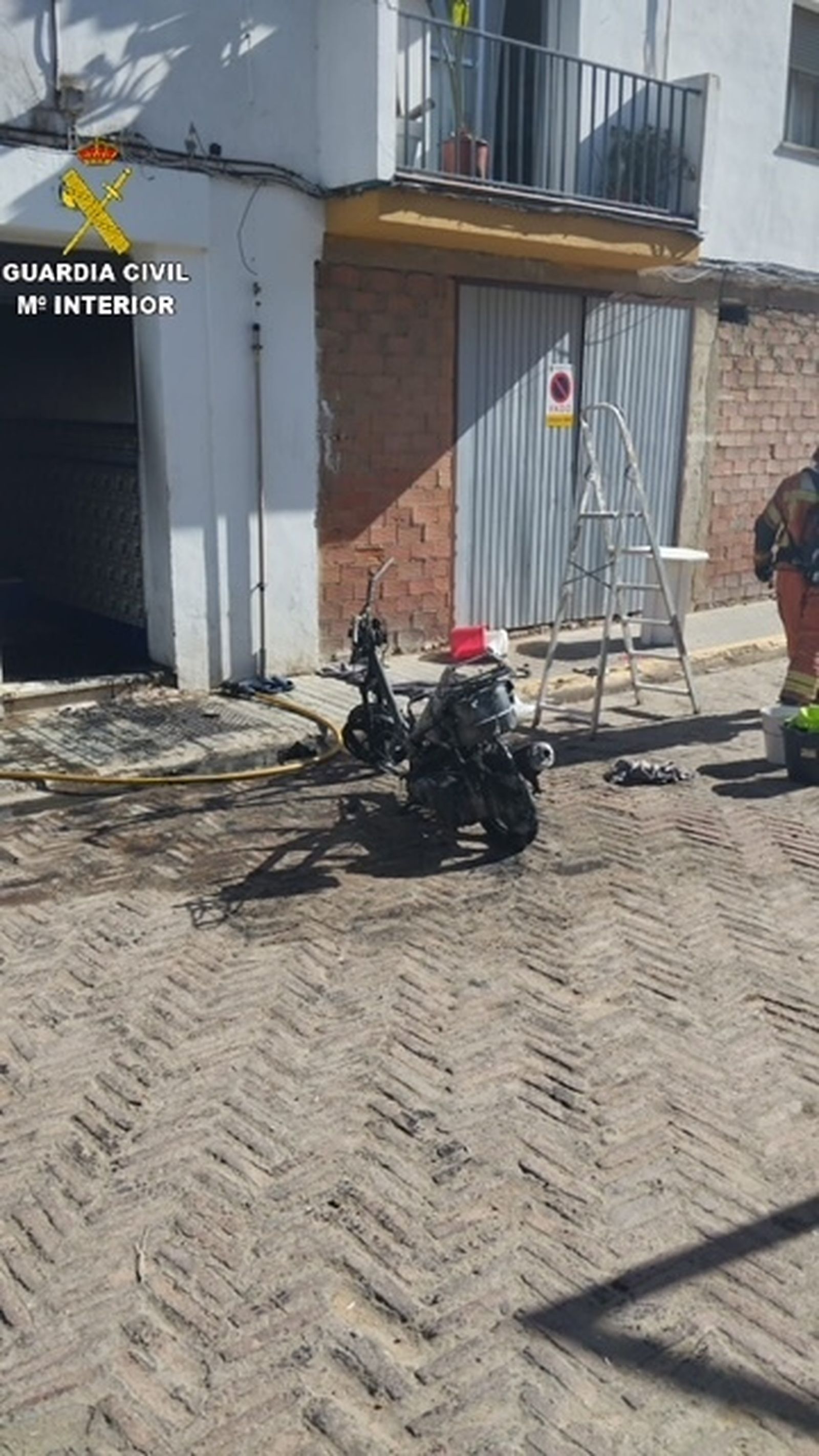 La motocicleta que ardió en el portal del bloque de viviendas de Lepe.