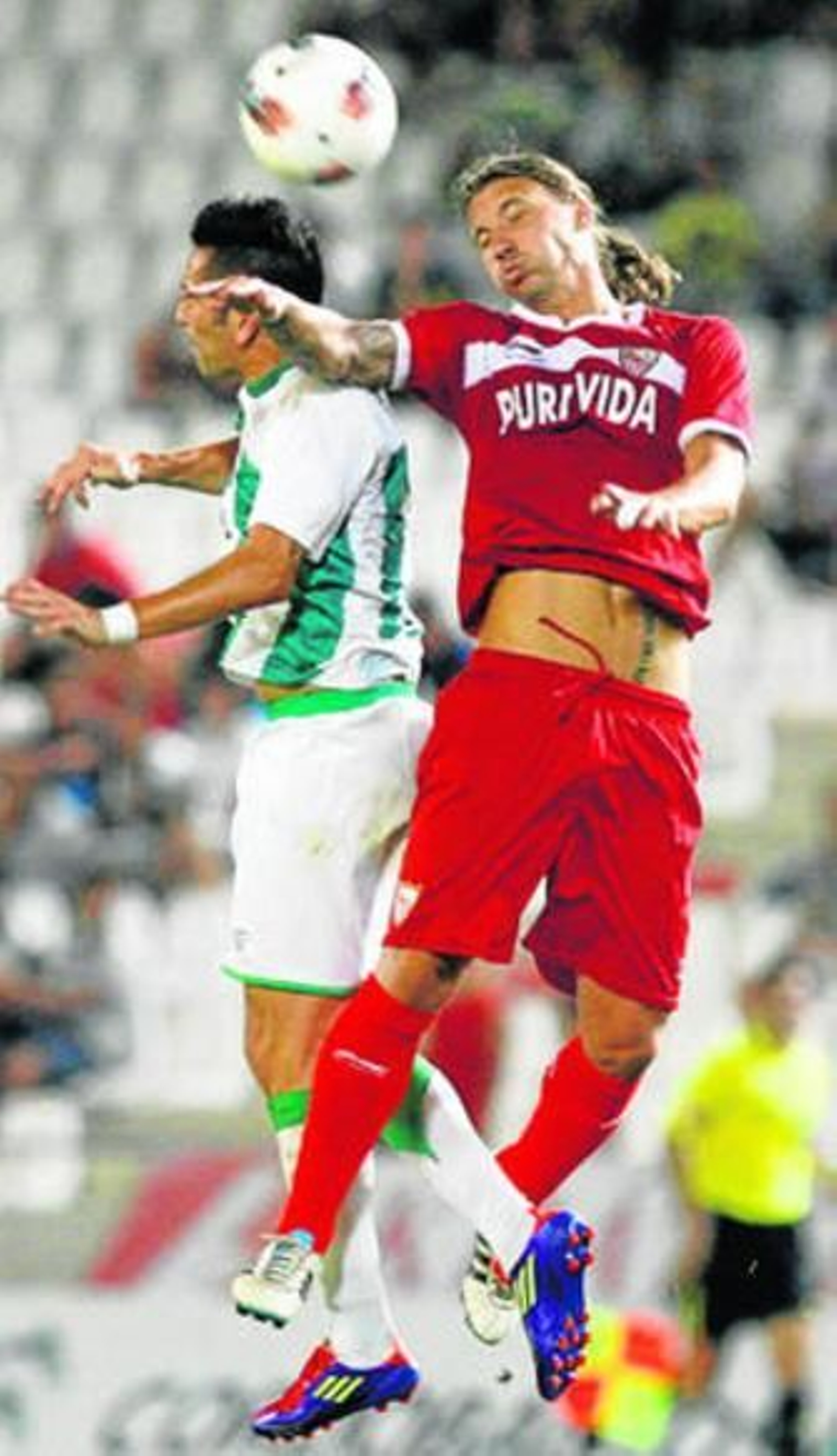 Charles busca un balón alto con el defensa Alexis.