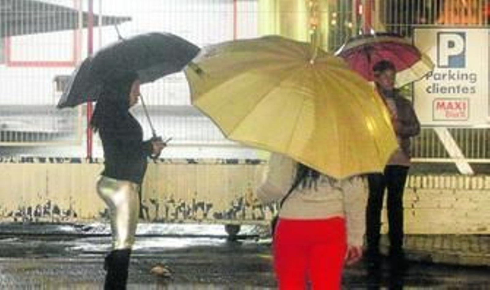 Tres jóvenes esperan clientes junto a los aparcamientos de un supermercado de Su Eminencia, la noche del sábado.