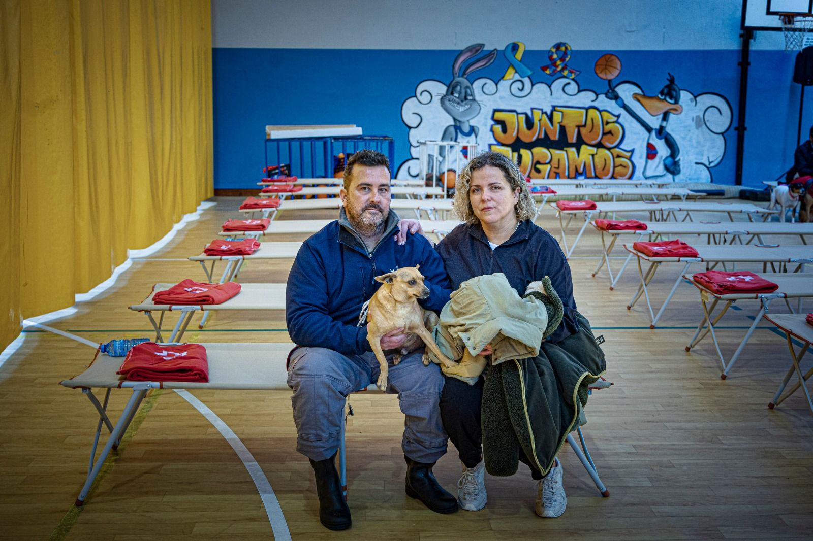 Rafa, un vecino de La Pedrosa, posa junto a su mujer y su perro en el polideportivo de Arcos tras ser desalojados.