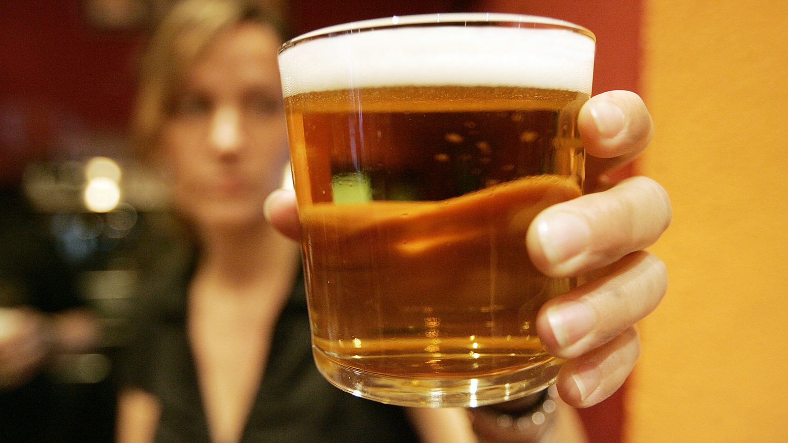 Un mujer sostiene una cerveza.