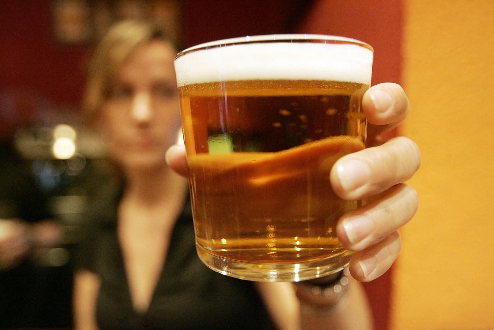 Un mujer sostiene una cerveza.