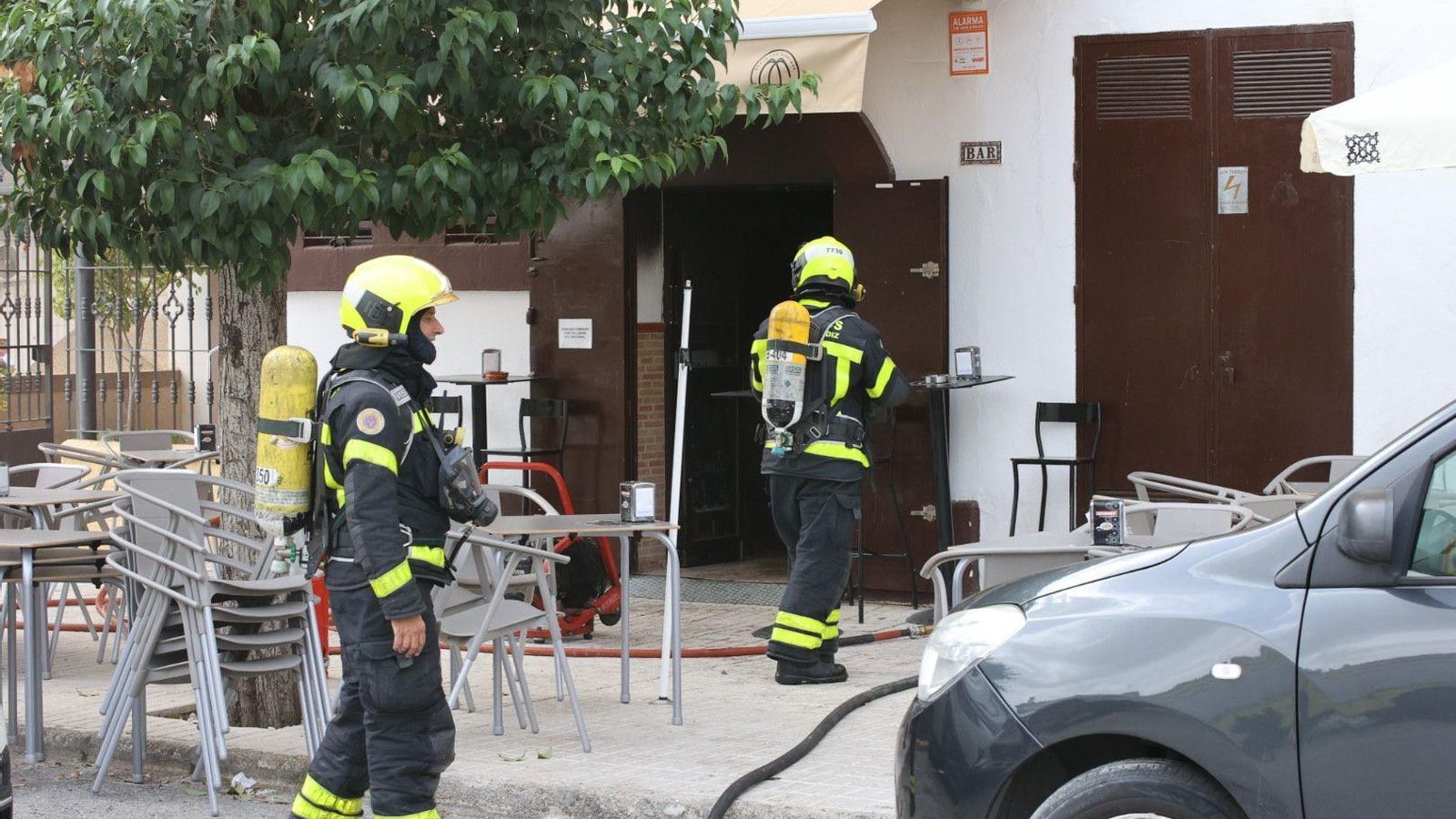 Bomberos con bombonas de oxígeno accediendo al local.