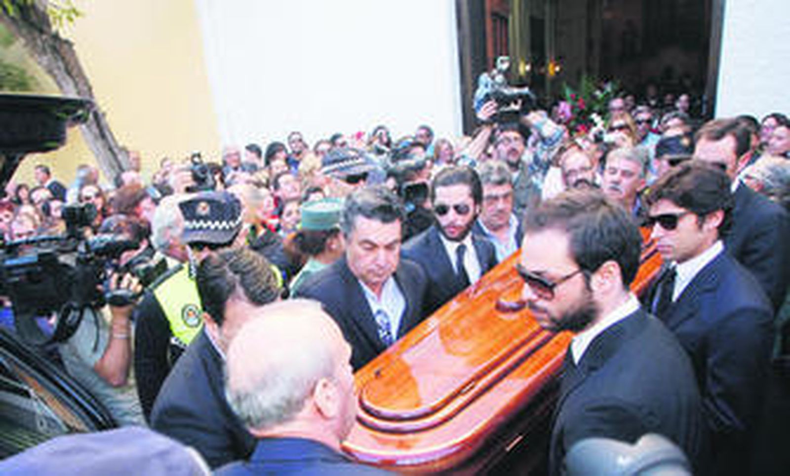1. Como manda la tradición, la familia Rivera recibe el pésame de sus convecinos en el altar de la parroquia. 2. Cayetano Rivera atiende a los medios de comunicación a las puertas del cementerio de Barbate.. 3. Diversos miembros de la familia Rivera portan el féretro de Antonio Rivera Alvarado desde la parroquia hasta el coche fúnebre. 4. Antonio Rivera consuela a su hermano José a su llegada al cementerio. 5. José Antonio Canales Rivera y su esposa abandonan el cementerio tras el entierro de su abuelo.