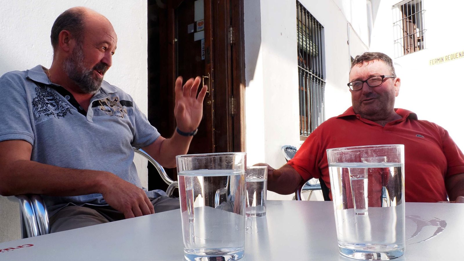 Miguel Fari y Vicente González hablan sobre la falta de agua mientras toman un 'aguaillo' en un bar de Higuera de la Sierra