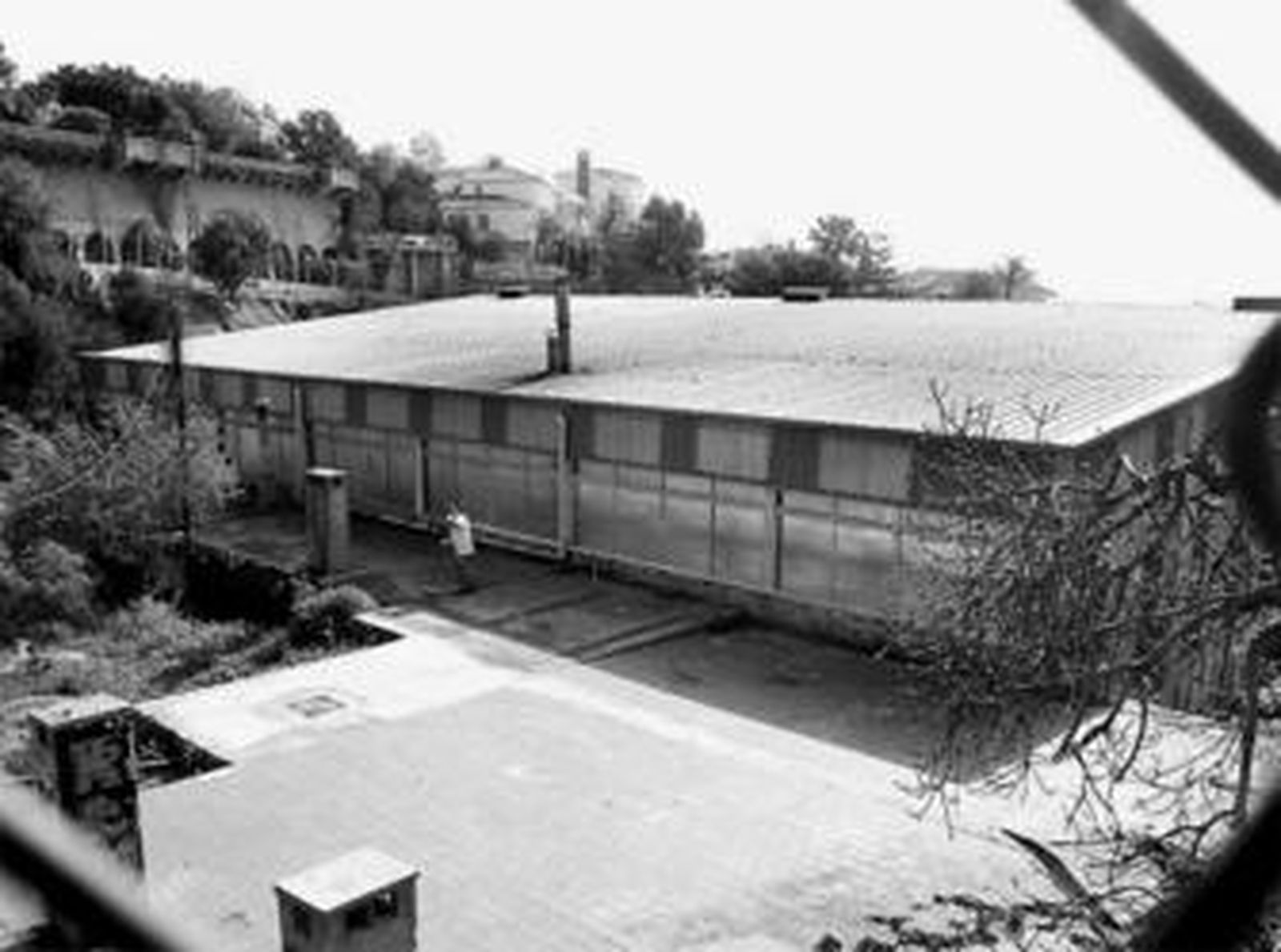 Un empleado recoge cristales del suelo junto a las vidrieras rotas, que fueron cubiertas con plásticos.