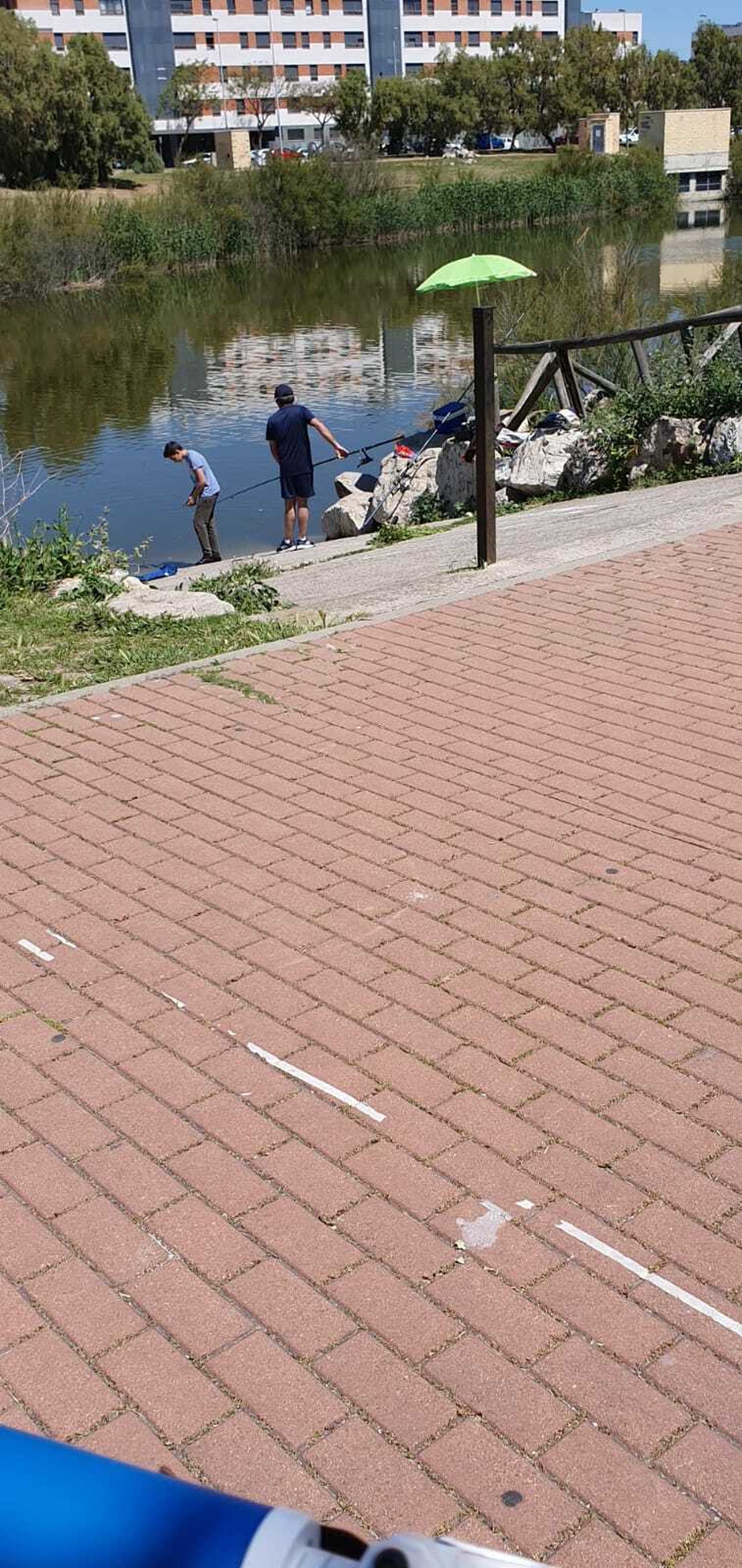 Dos personas, pescando en plena Laguna de Torrox.