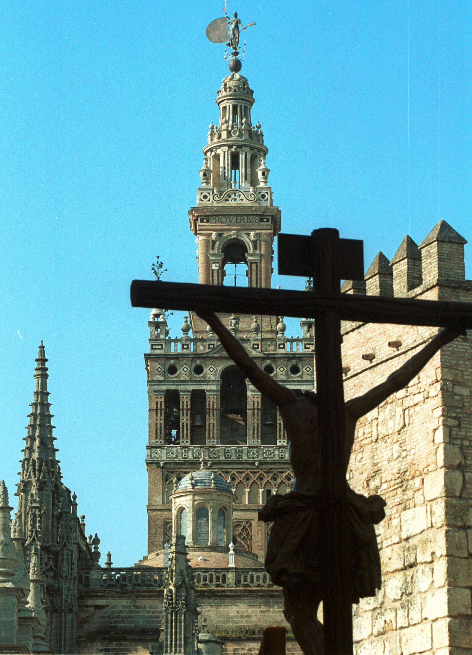 El Cristo de la Buena Muerte en el contraluz único de la Giralda y los remates de la Catedral.