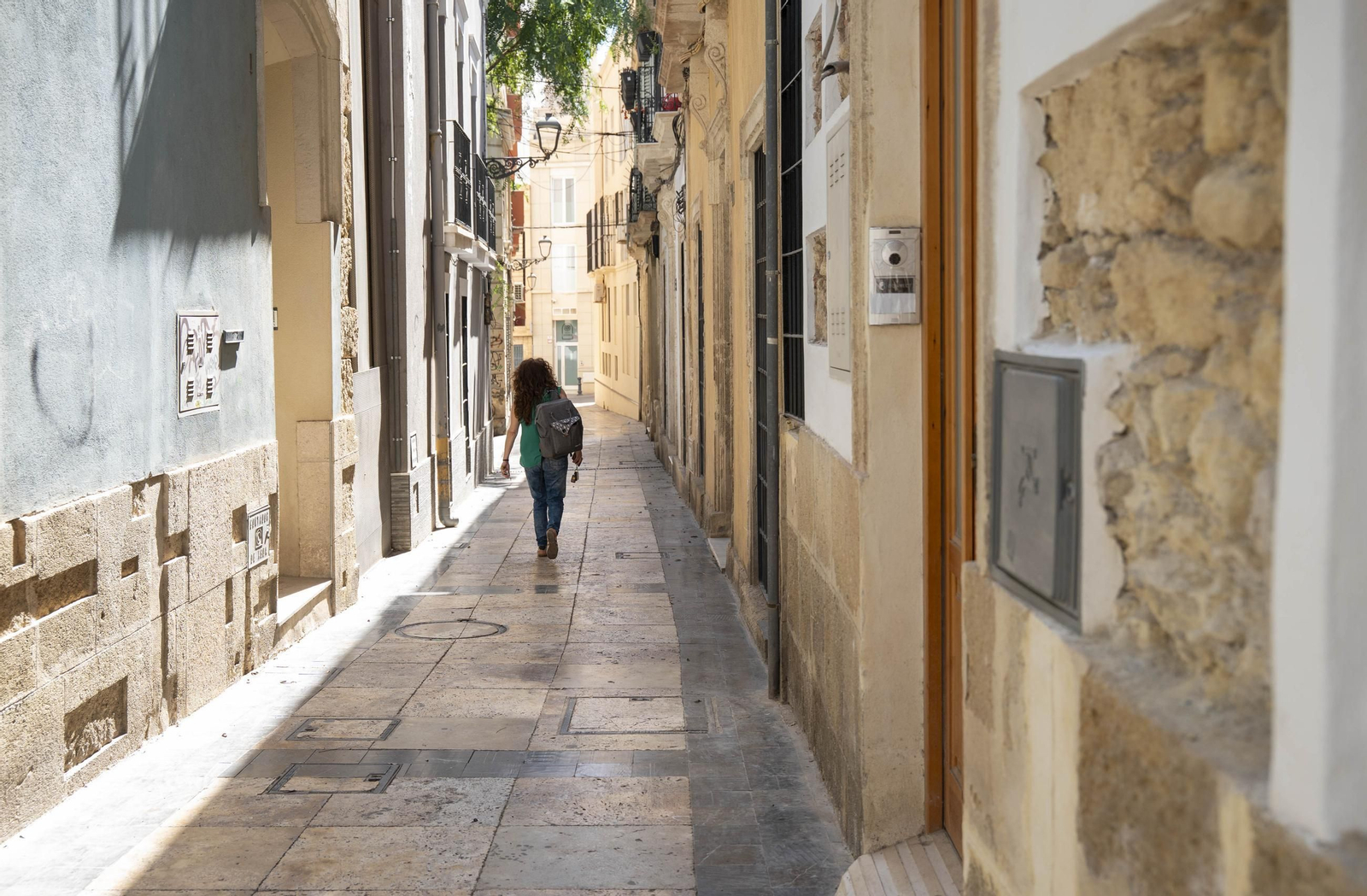 Una mujer camina por una de las tantas calles estrechas que posee el Casco Histórico de Almería, donde aumentan exponencialmente las viviendas de uso turístico.