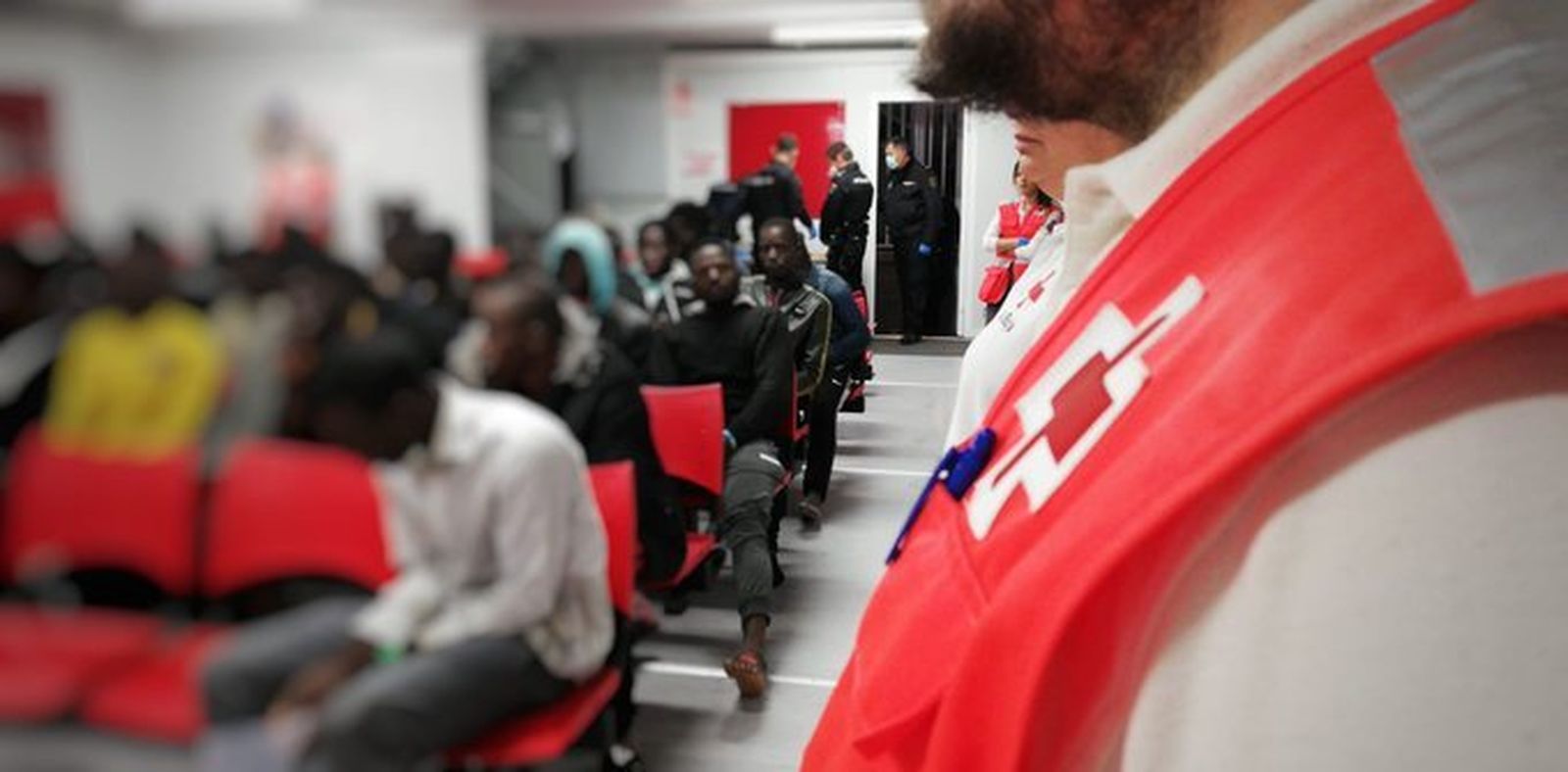 Voluntarios de Cruz Roja atienden a los inmigrantes con la vigilancia de la Policía Nacional