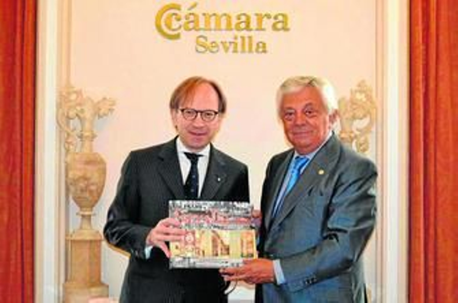 El embajador de Italia en España, Pietro Sebastiani, recibe un libro de Sevilla del presidente de la Cámara.