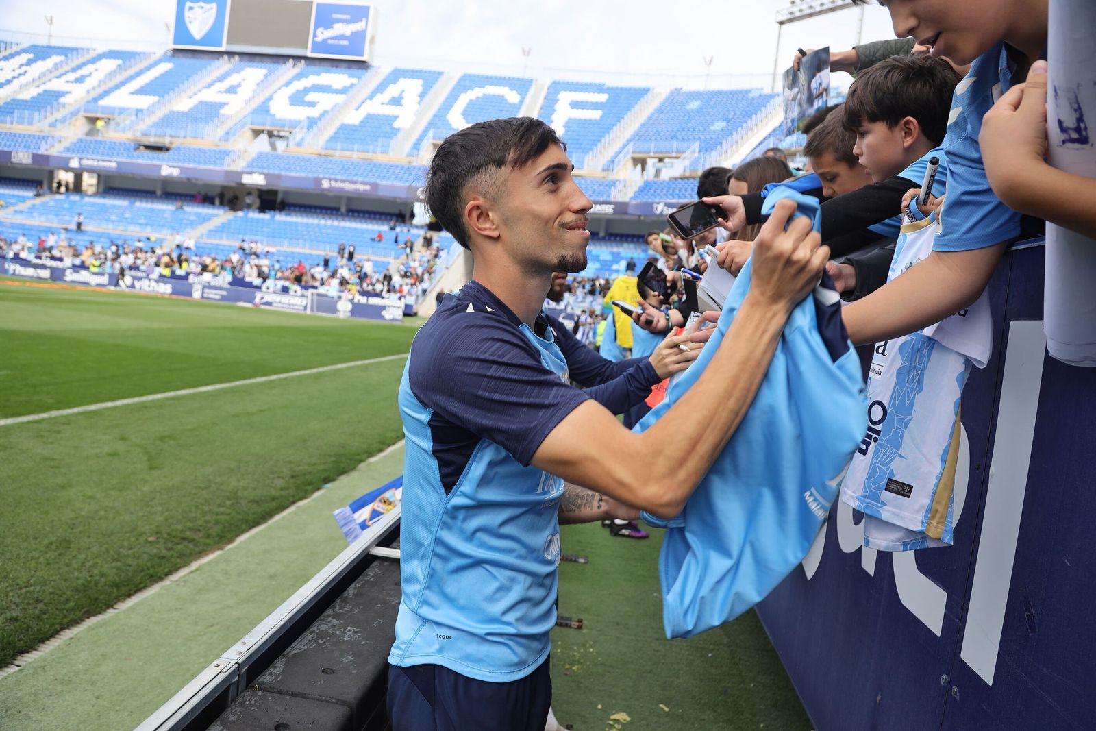 Larrubia firma autógrafos.