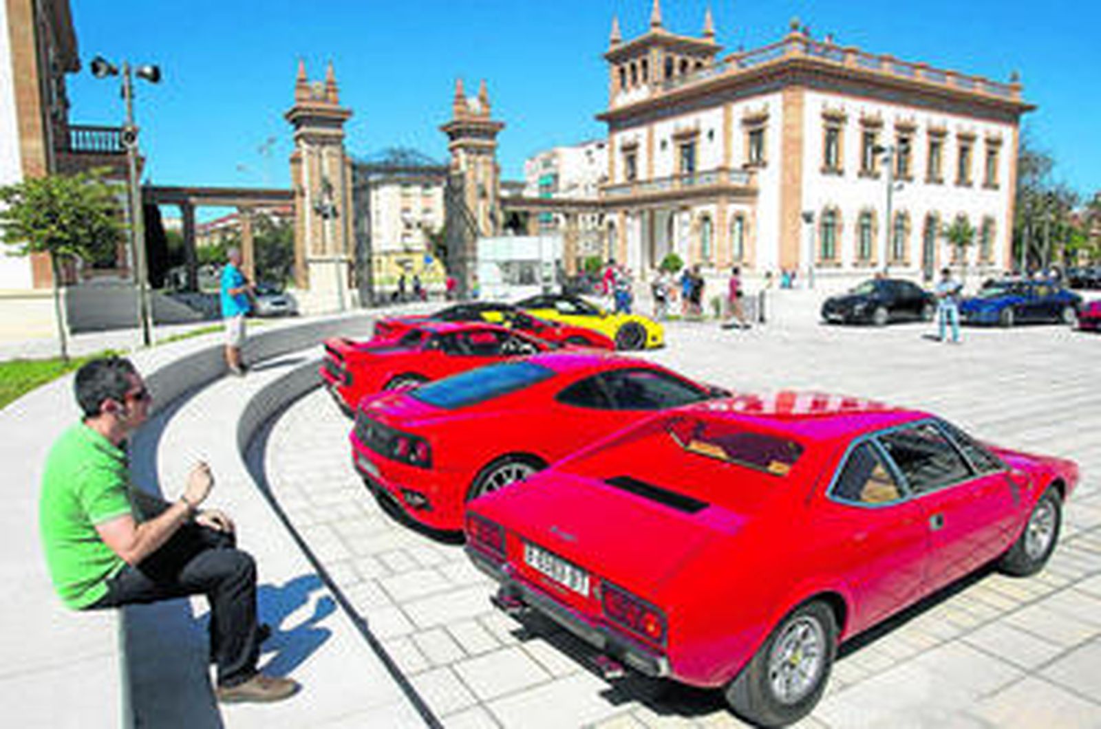 Un visitante se sienta a ver la parte trasera de varios Ferrari.