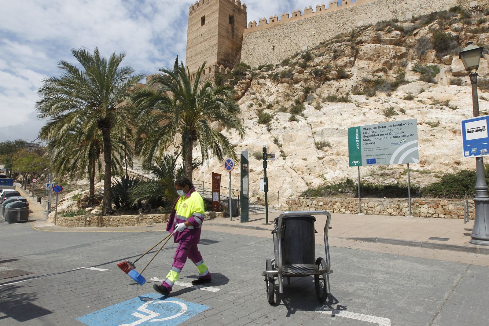 Una trabajadora del servicio de limpieza viaria junto a la Alcazaba