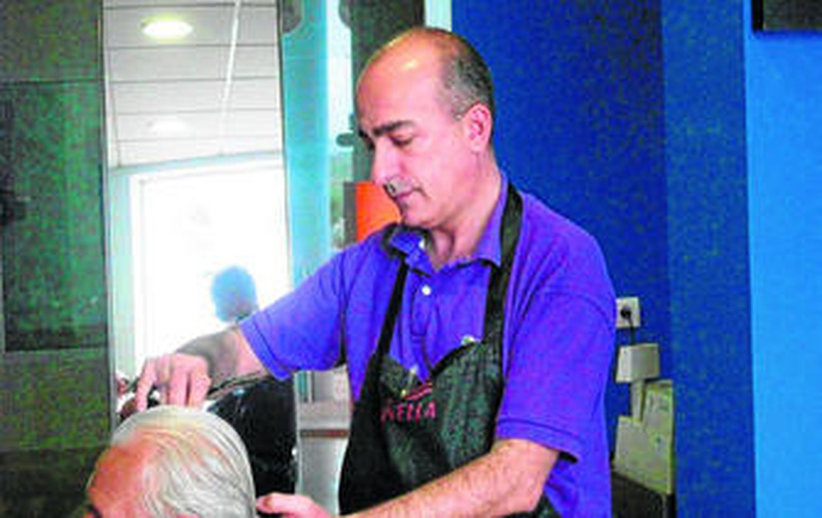 Antonio Soler Gómez durante una jornada de trabajo en su peluquería.