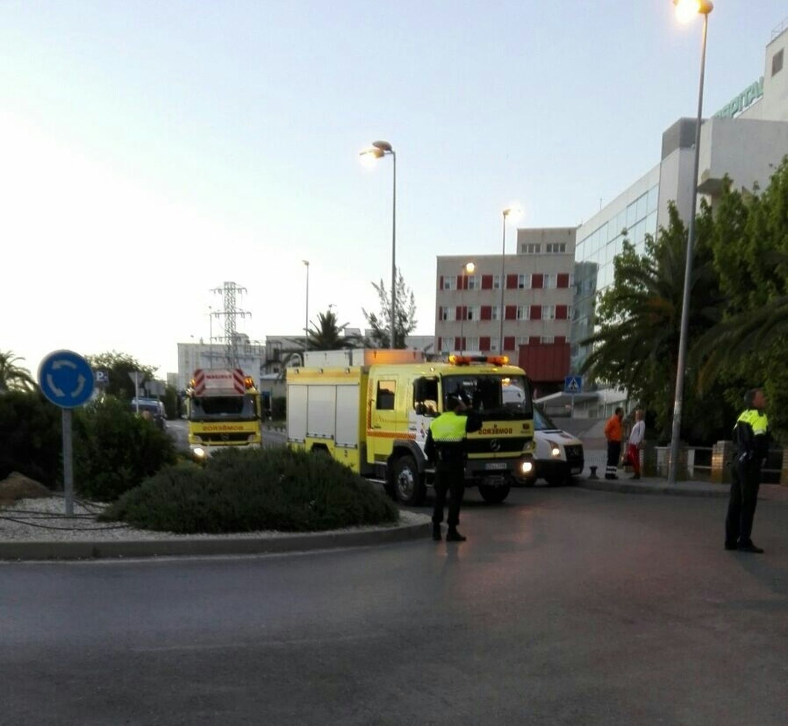 Un policía local da paso a dos camiones de bomberos ayer en el hospital.