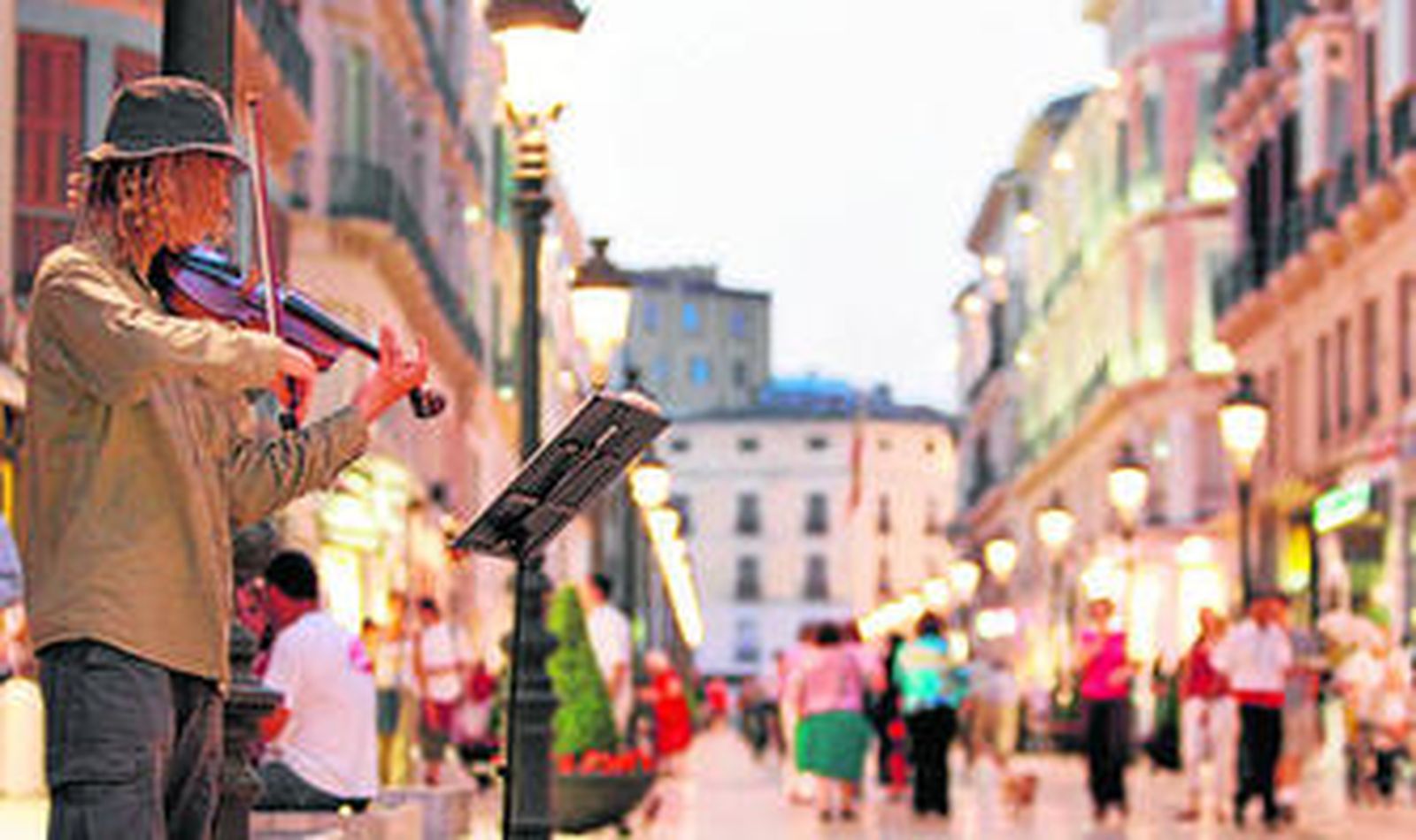 Un músico callejero actúa, en una imagen de archivo, en plena calle Larios.