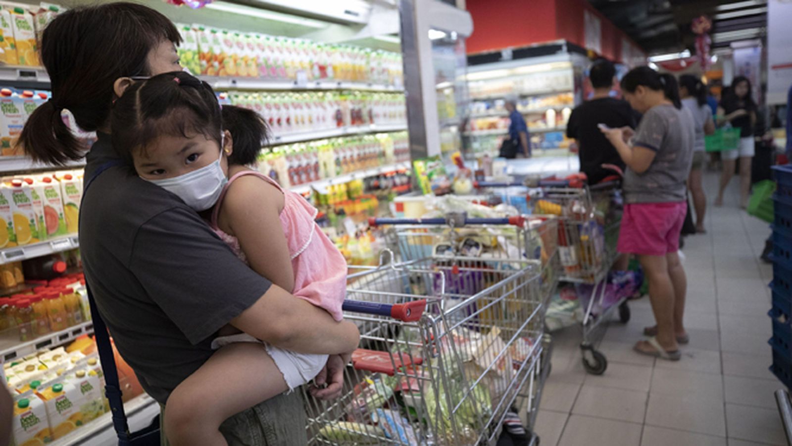 Clientes con y sin mascarillas en un supermercado de Singapur.