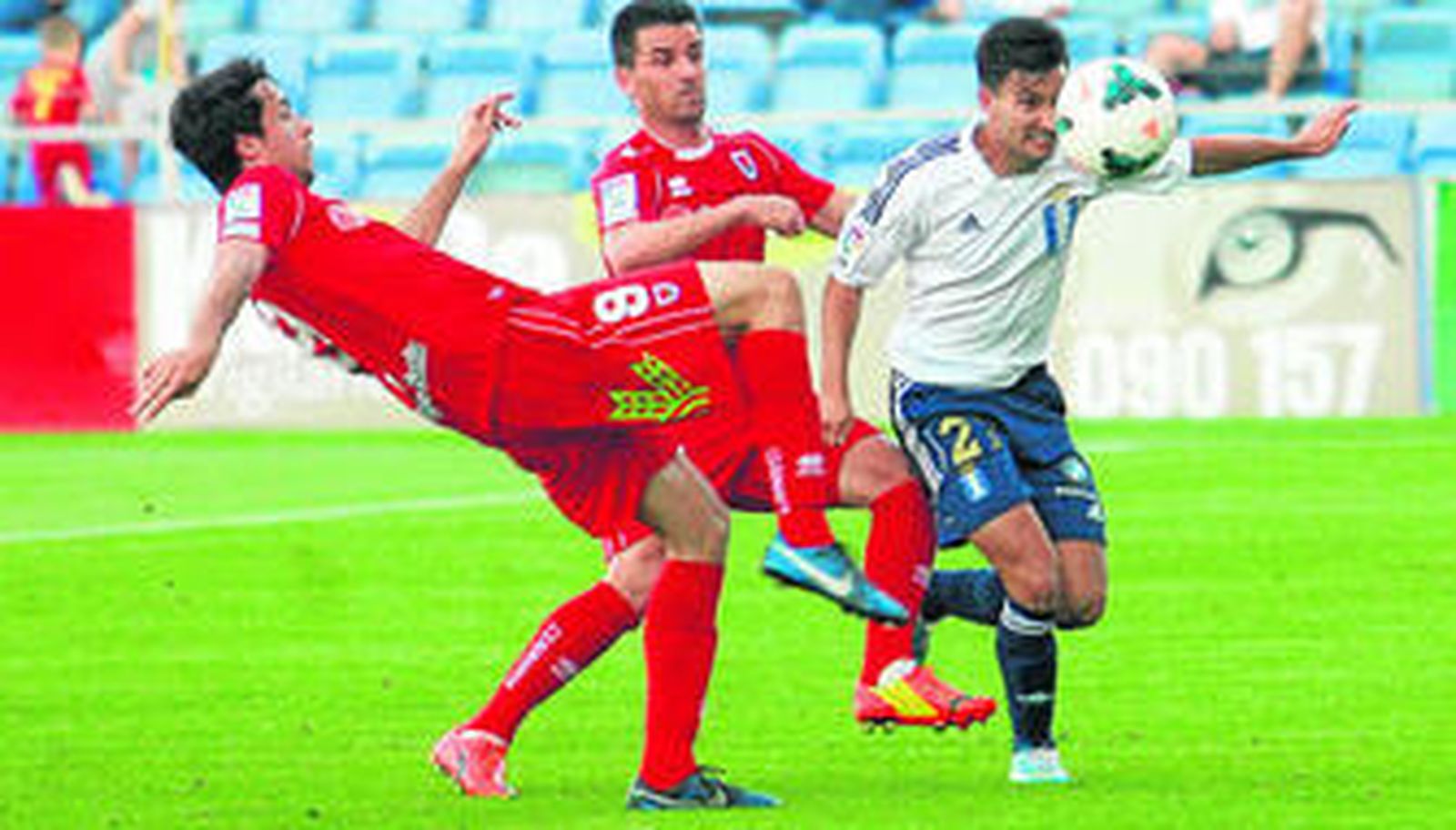 Tomás Girón pugna por hacerse con el control del balón con dos jugadores del Numancia, durante el partido del pasado domingo en el Nuevo Colombino.