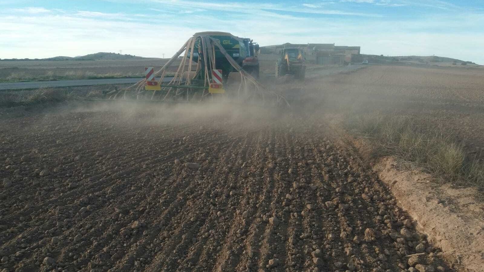 Un tractor arando un bancal. Ni gota de humedad, todo polvo y tierra.