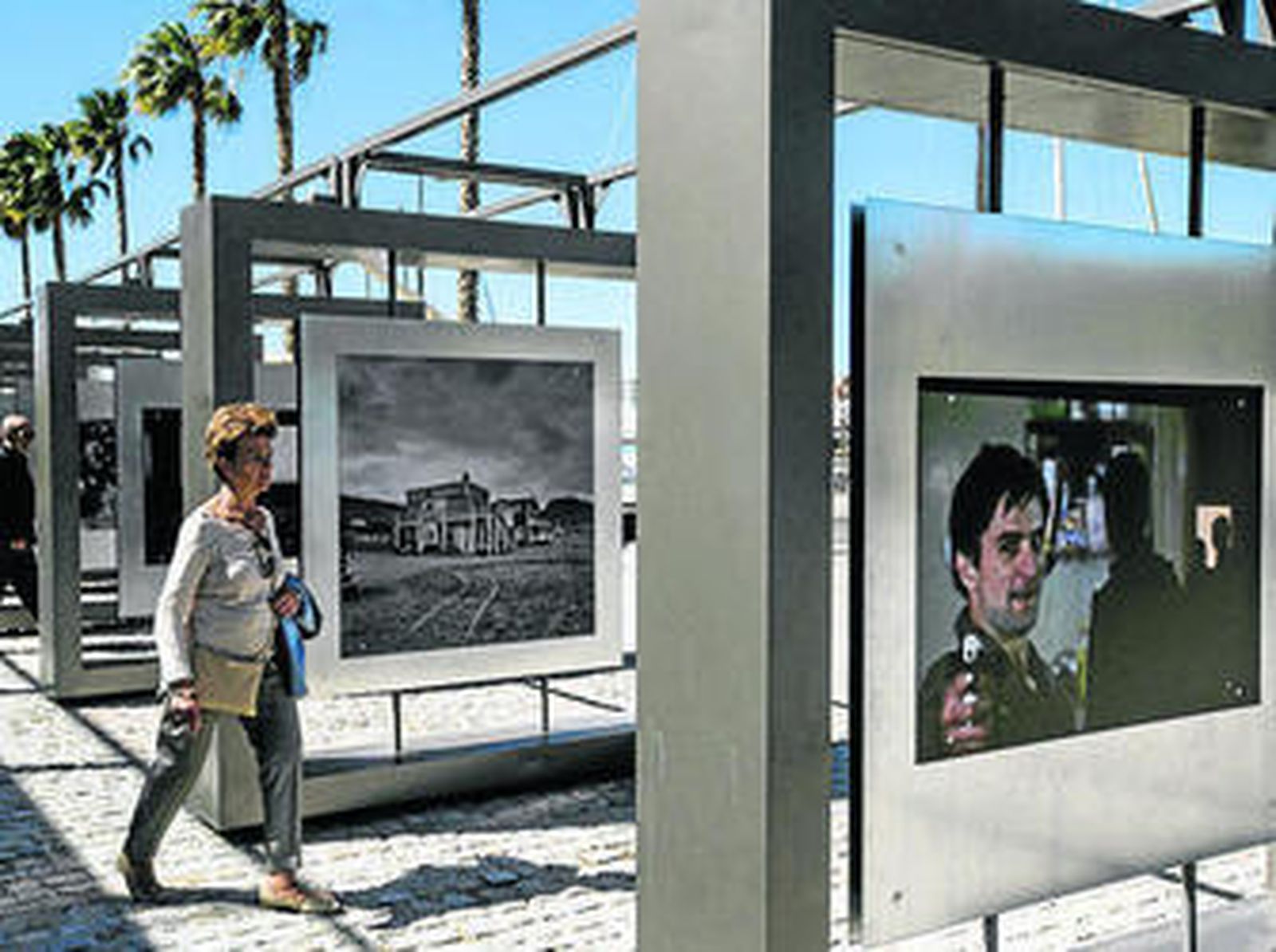 Una mujer junto a algunas de las fotografías de la muestra.